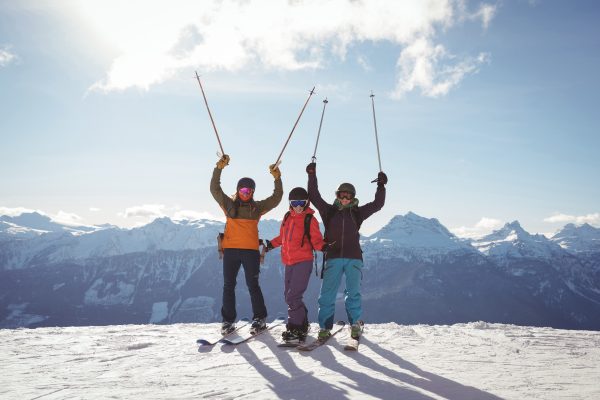 celebrating skiers standing on snow covered mountain scaled